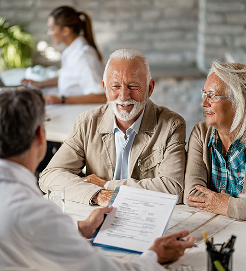 happy-senior-couple-communicating-with-agent-about-their-health-insurance-while-going-through-paperwork